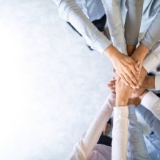 Close up top view of young business people putting their hands together. Stack of hands. Unity and teamwork concept.